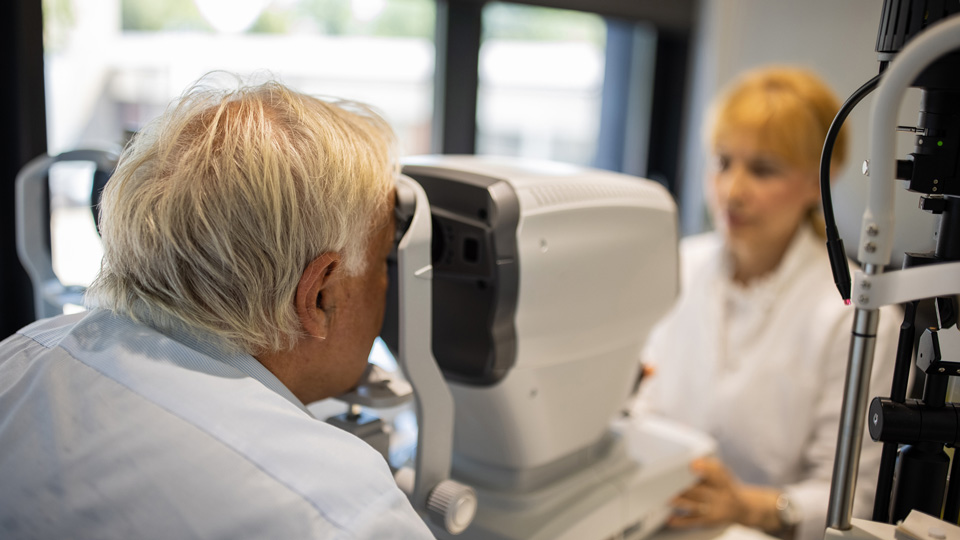 Elderly man has a retinal scan during an eye exam