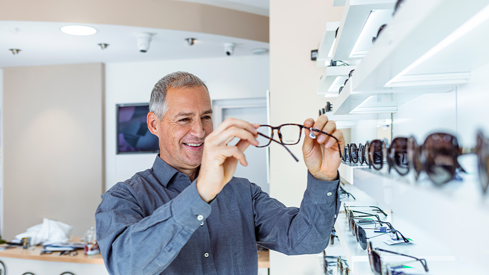 Older man looking at glasses 