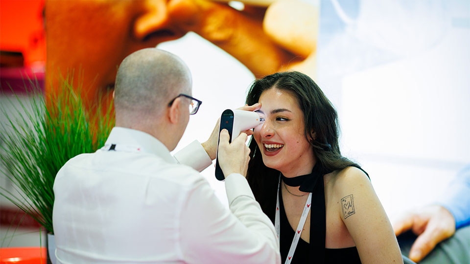 A woman has her pressures checked with a handheld tonometer at 100 Optical
