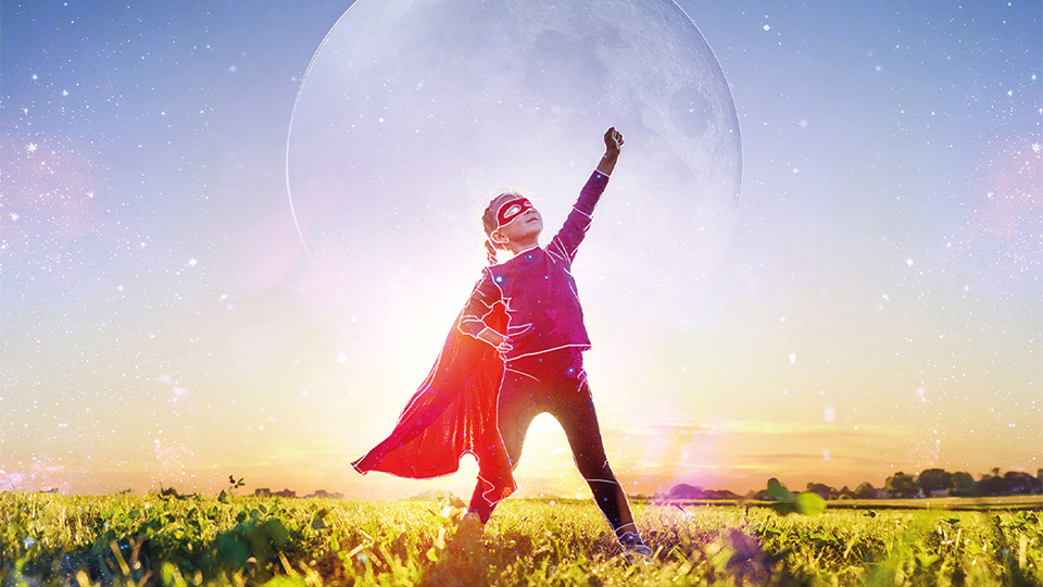 An illustrated child poses in a cape like a superhero, a moon is superimposed in the background