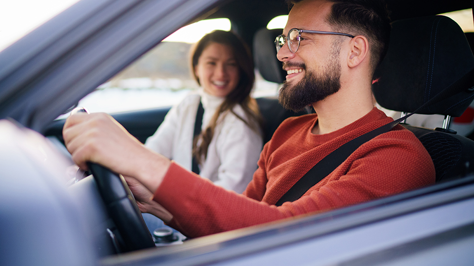 A man and a woman are traveling by car
