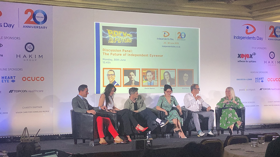 Panelists sitting on chairs on stage