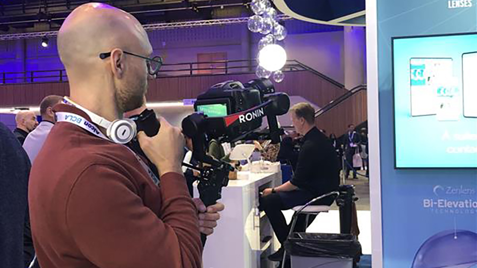 Laurence Derbyshire standing holding a camcorder filming