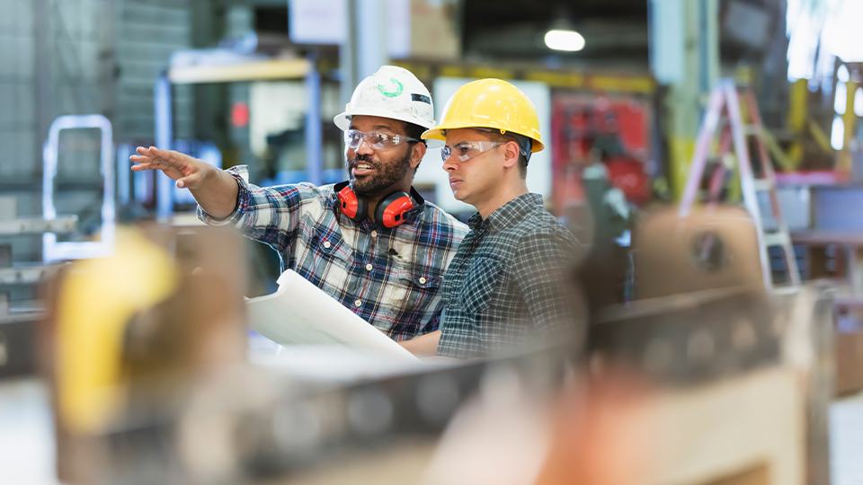 Construction workers in a warehouse wearing safety glasses
