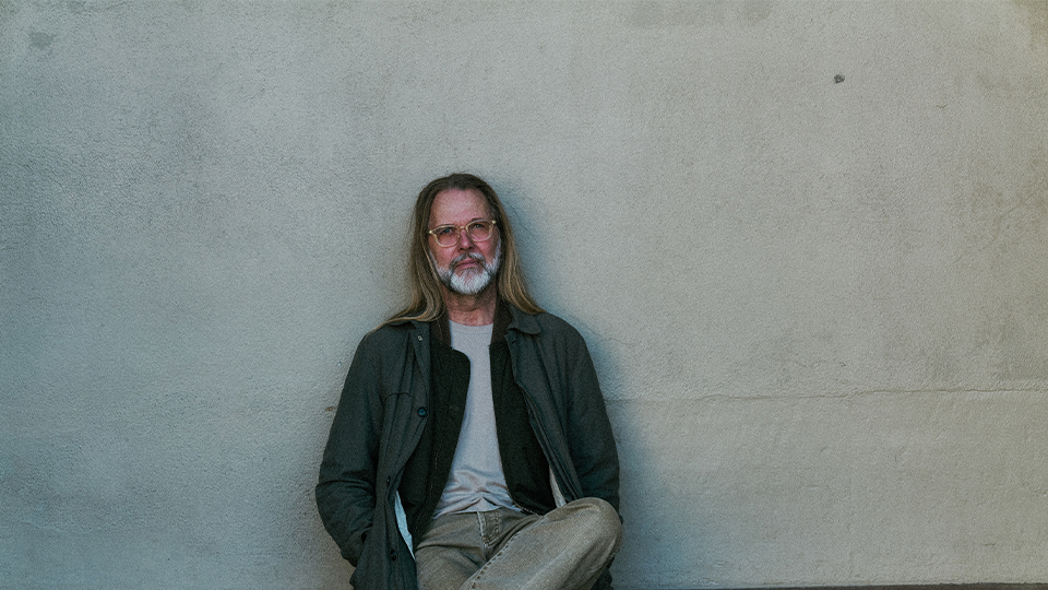 Lars Malmsten wears a long green coat and pale yellow 
