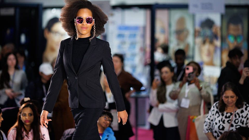 A model walks the stage at 100% Optical