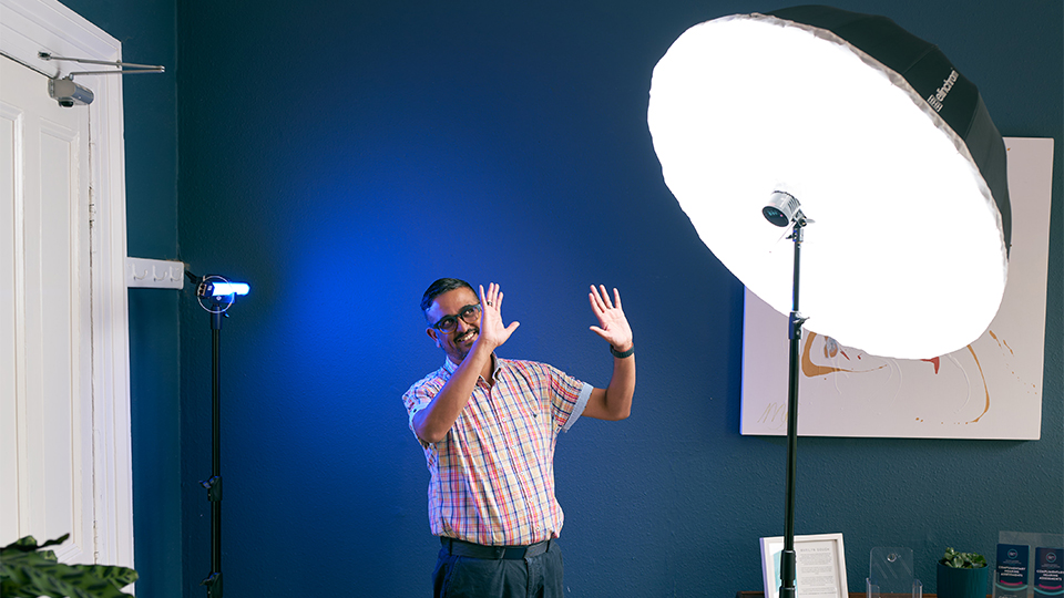 Ankur Trivedi holds his hands up to a large photographic light