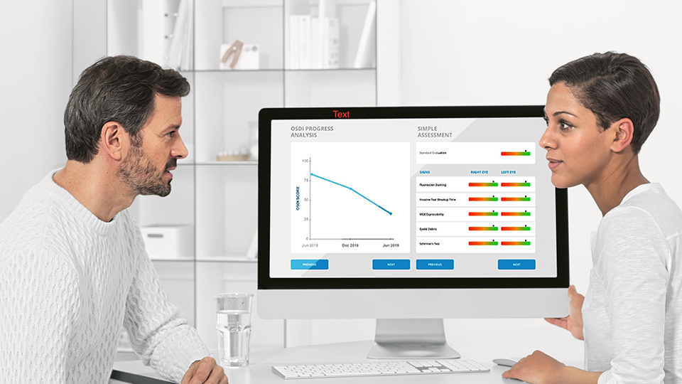A patient and practitioner sit opposite each other talking about results on a computer screen between them
