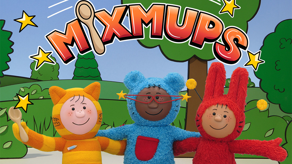 The main characters of Mixmups: Giggles the cat, who is in a wheelchair wears of pencil badge and holds the magic spoon. Pocket the bear has amazing slimline cat’s eye red frames with gold stars on each point, her tummy has a red pocket. Slim is on the right in vibrant red with bunny ears. In front of them sit their assistance pets, a guinea pig and a dog
