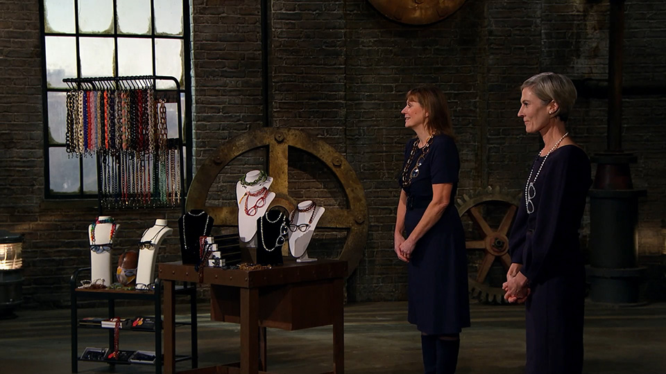 The brand co-founders presenting their frame chains in a room with exposed brick walls and mill parts, reminiscent of a refurbished warehouse
