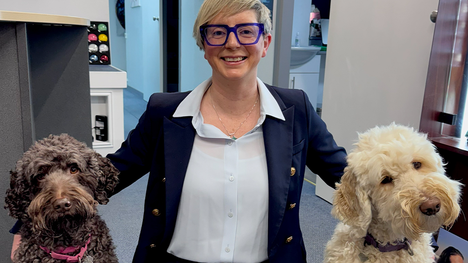 Lindsey kneeling down with dogs on her right and left