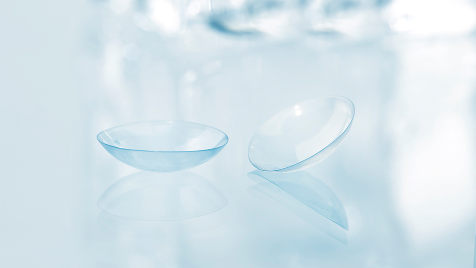 Transparent contact lens on a light blue background