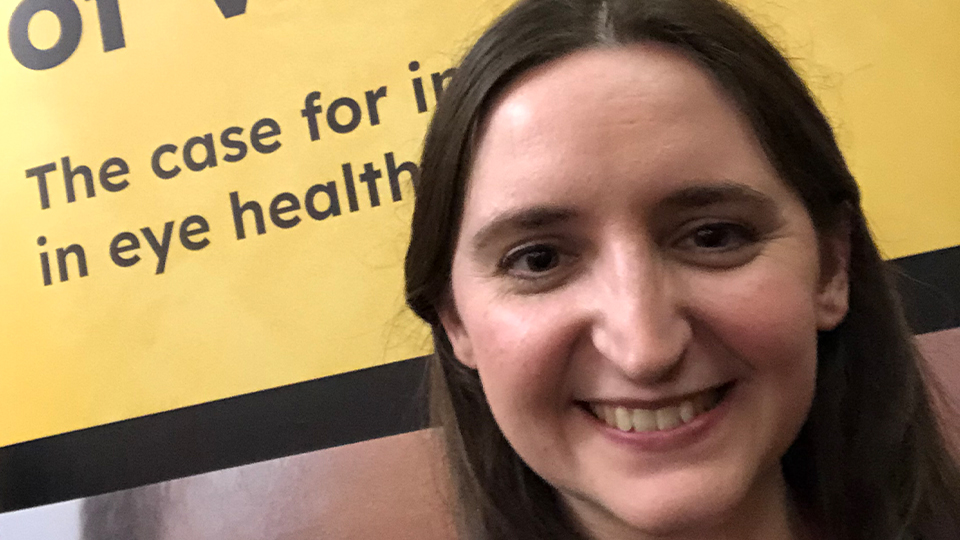 Kimmy Young in front on a yellow sign