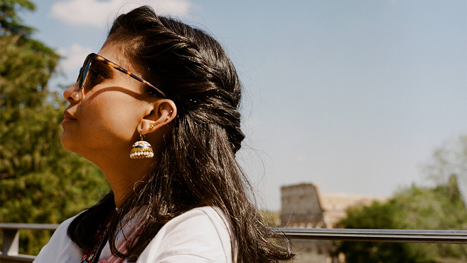 Faayza looks to the side with the Colloseum blurred in the background