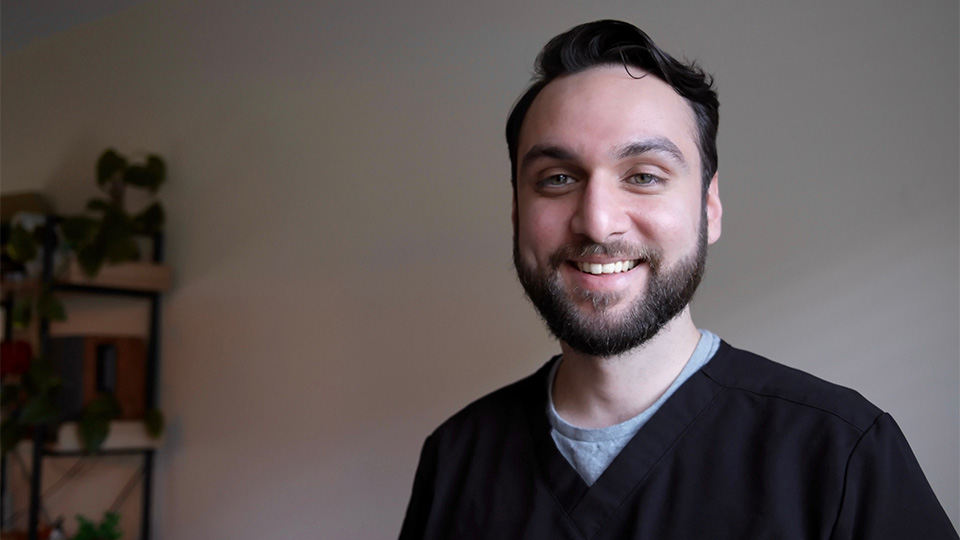 Kumell Rizvi, hospital optometrist in blue scrubs