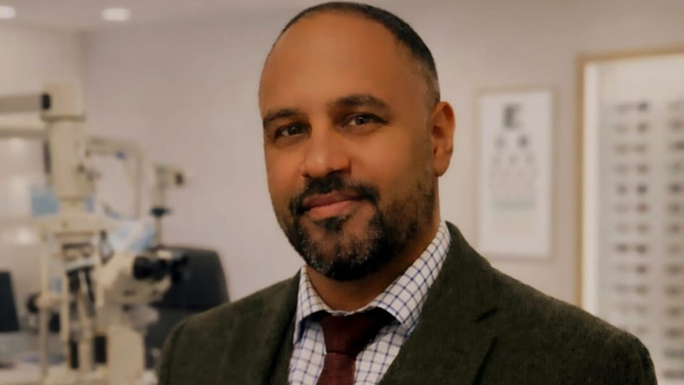 Haris looks at the camera whilst wearing a grey suit