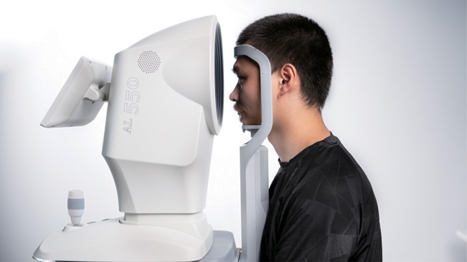 A man is positioned at the AL551 biometer device for a test