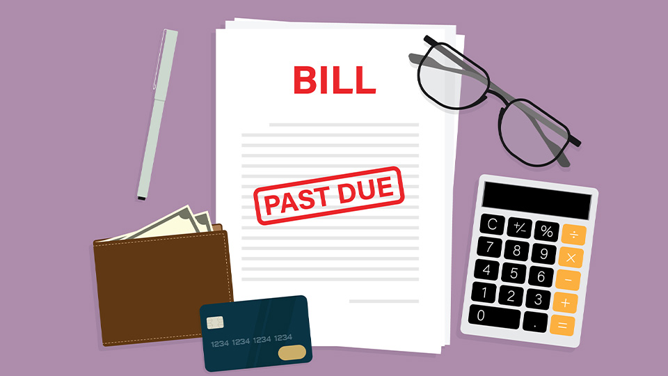 Financial bill with past due sign, pen, glasses, calculator, credit card and a wallet on the table