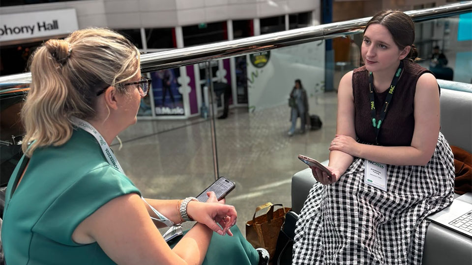 Kimmy Young sitting interviewing Kirsteen Newman on a sofa