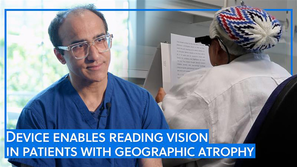 Mahi Muqit in blue scrubs and clear acetate spectacles is on the right, photographed mid-interview, while a patient, Sheila, is pictured from over the shoulder as she practices reading with the device. A blue border, indicating an OT video, is connected to a title stating: Device enables reading vision in patients with geographic atrophy