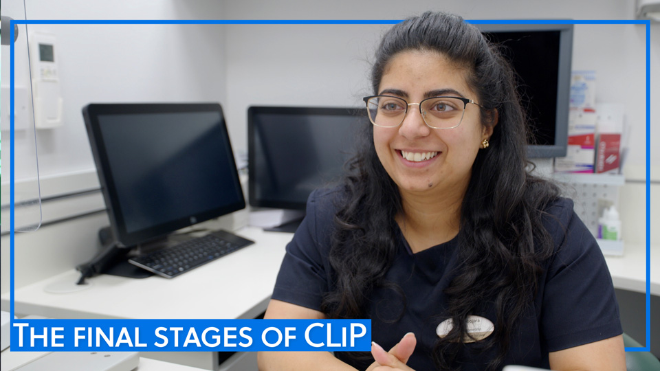 Deepali Poojara sitting at a desk smiling at the camera