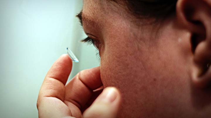 Patient applies a contact lens