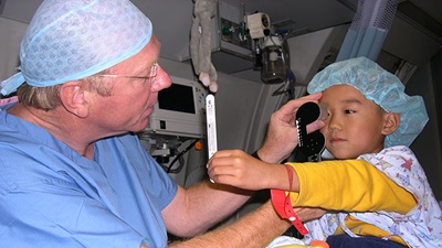 Robert Walters treating a child during an Orbis trip