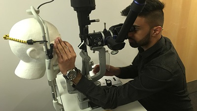 Optometrist at EOS workshop practising clinical skill on model head