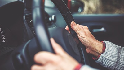 old persons hands on wheel