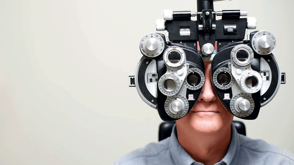 Man looking through phoroptor