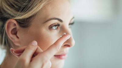 woman putting in a contact lens