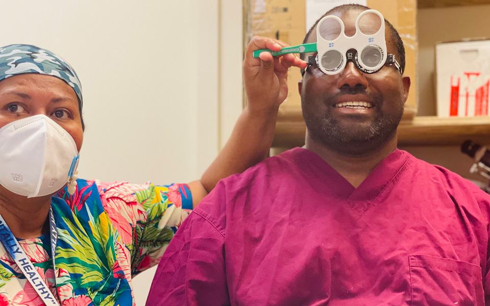IAPB photo competition runner up. Eye care professional performs a refraction on another health worker in what has become a COVID-19 storage room