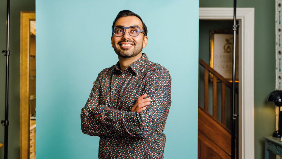 Optometrist Deepak Oberai standing with his arms crossed and smiling. 