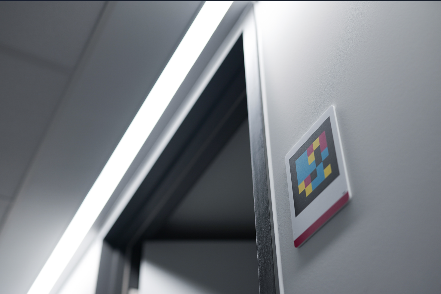 A low image tilting up to see the corner of a doorway, with a bright white strip of light across the top, and on the right-hand-side, a sign with a colourful QR code. 