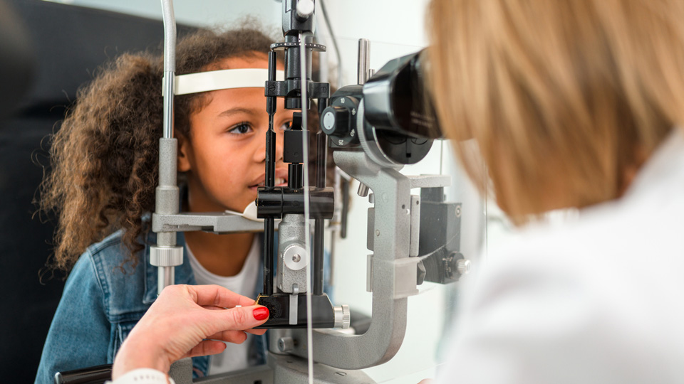 Curly brown hair girl sitting at optometrists