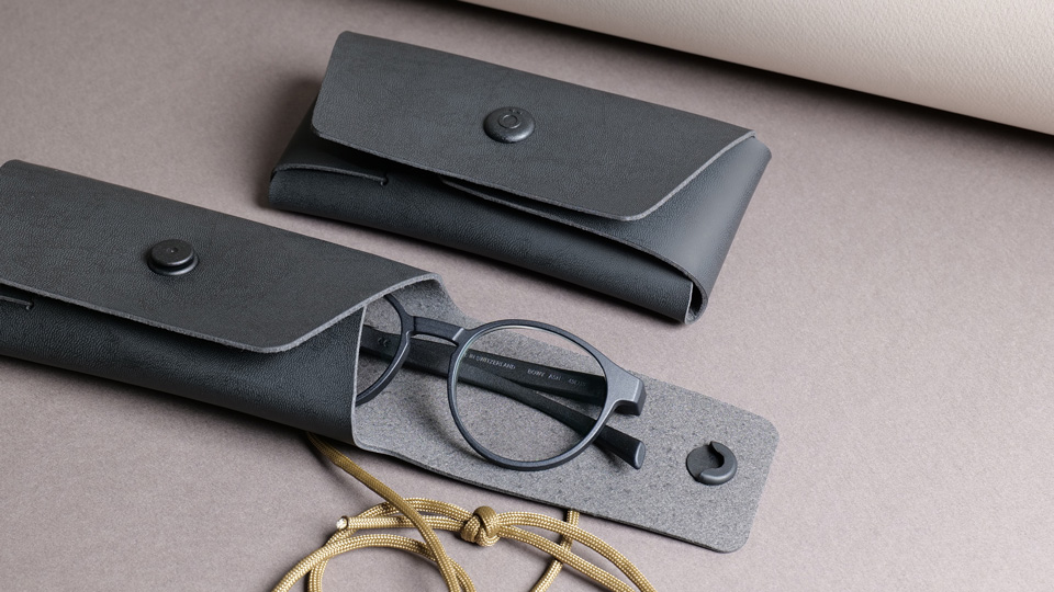 Gotti’s case is a think leather-like texture, with small circular pop clasps and a cord.