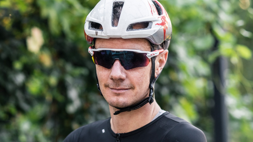 Alistair Brownlee, MBE, wears cycling gear, including a helmet and Oakley Radar EV sunglasses. 