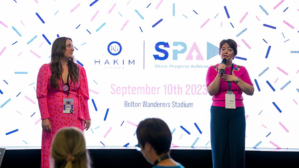 Erica Hopwood and Claire Slade present on stage in front of a screen 