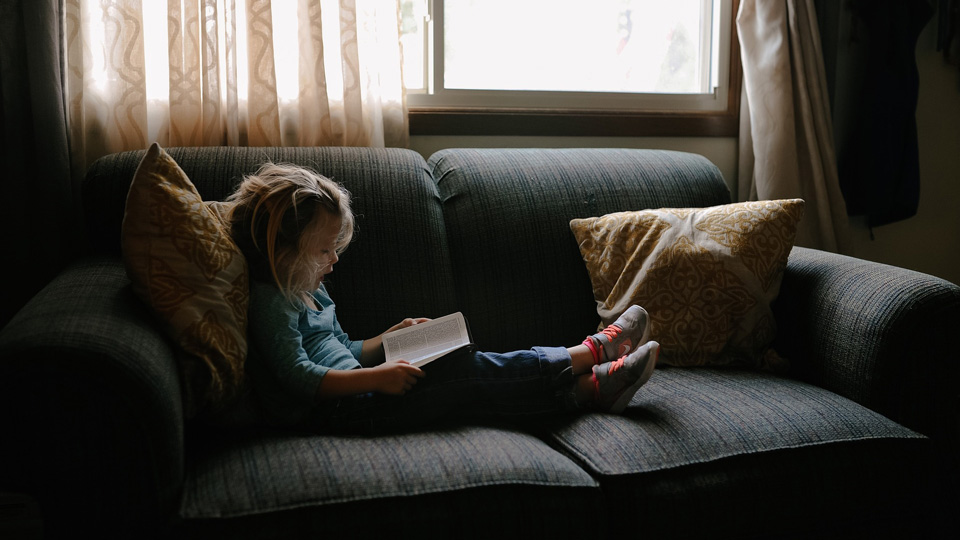 girl reading on sofa