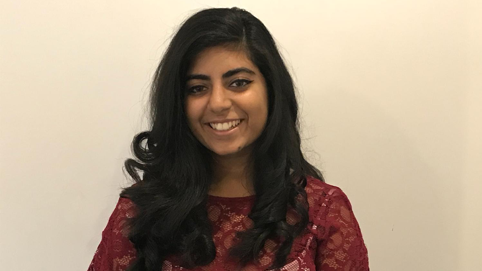 Deepali has her long hair down and is wearing a floaty red lace top
