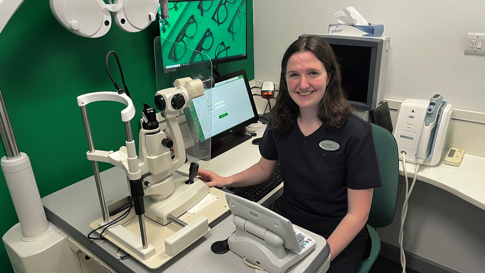 Hannah Silcock sitting in an optometry practice room