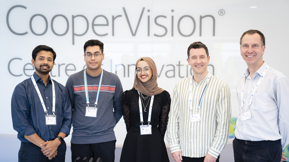 Samya and her teammate stand with key members of the CooperVision team, judging panel, and academics