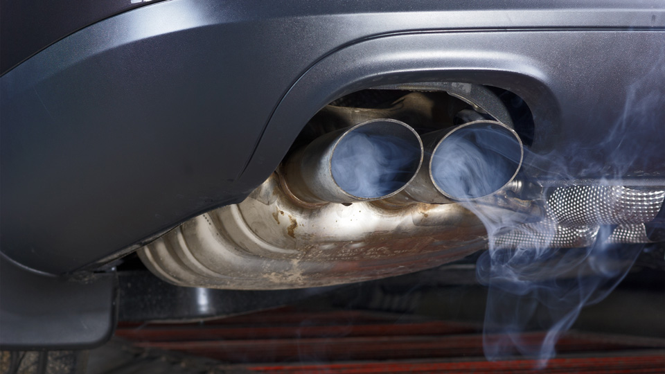 Exhaust pipe of a car, blowing out pollution, viewed from below  