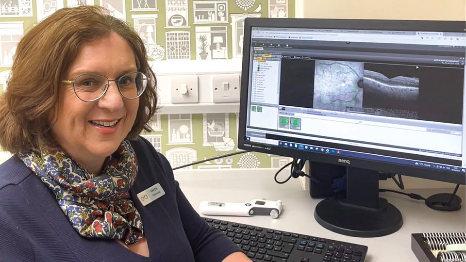 Karen Gennard is sitting in front of a computer screen that shows the Community Ophthamic Link software open 