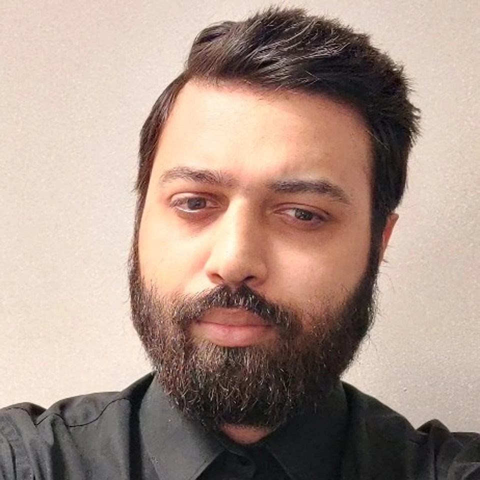 Headshot of a man, Niraj Patel, with black hair and a black shirt