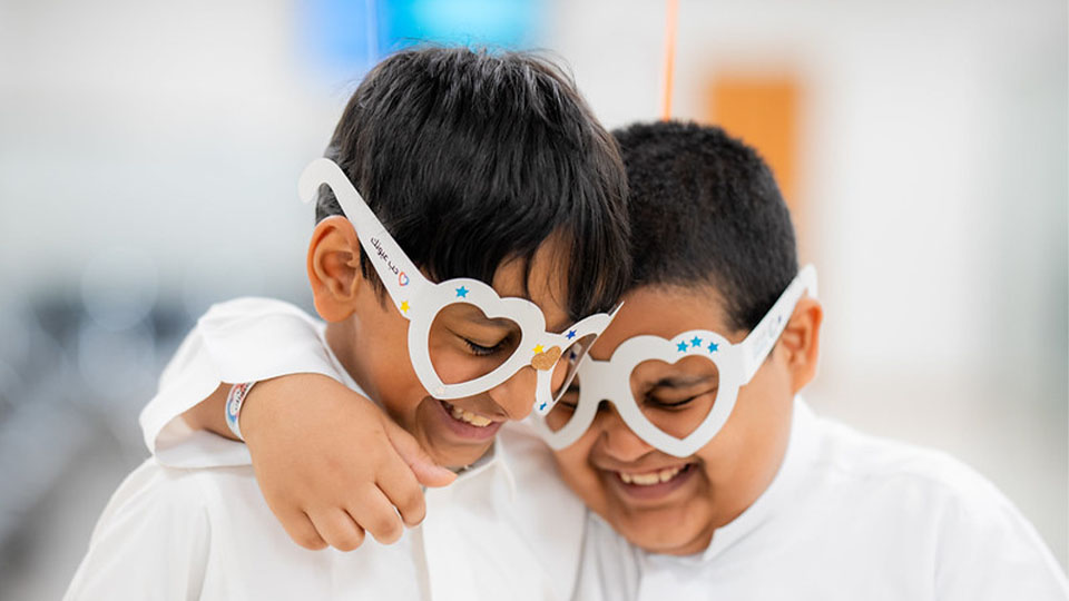 Two children hugging each other weather heart shaped paper frames