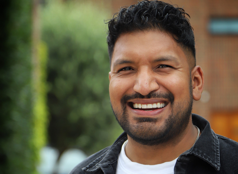 A man with black hair smiling