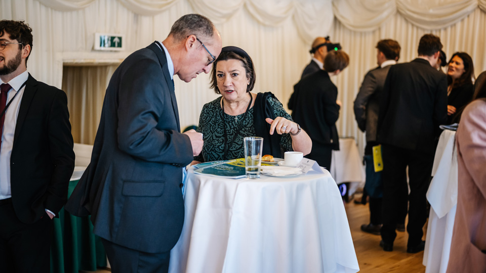Cathy Yelf, woman with short brown hair speaking to Ben Burton a man with a shaven head at Westminster Eye Health Day 