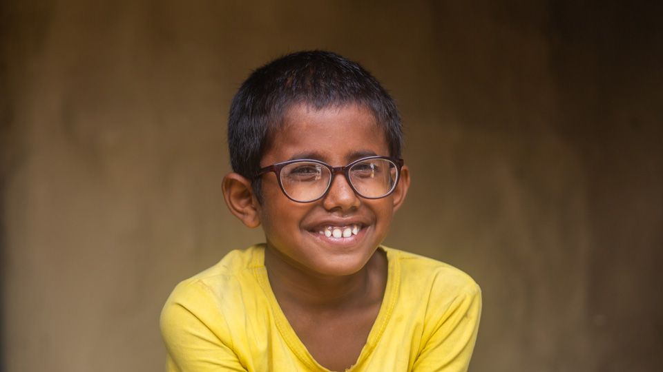 A child who has benefitted from an Orbis project smiles in new glasses