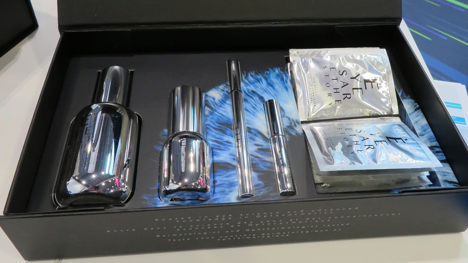 A luxury black box is open displaying the optocosmetics inside in sleek silver packaging